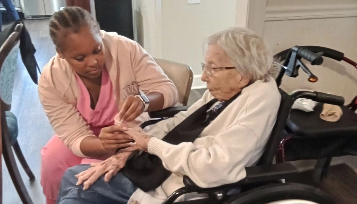 Nurse assisting a senior resident in a wheelchair at a compassionate senior care community