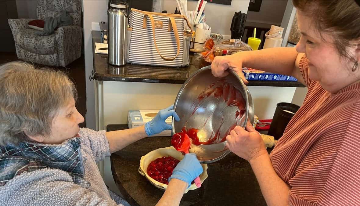 Nurse assisting senior with cooking